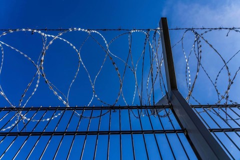 Symbolic image security, S-wire rolls, NATO wire, on a fence top, demarcation of a property,