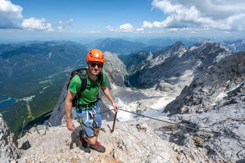 Mountaineer with helmet in a secured via ferrata, Zugspitze via ferrata, ascent to the Zugspitze,