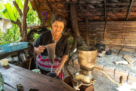 Karen woman in her kitchen in Mae Klang Luang village making coffee, Doi Inthanon National Park,