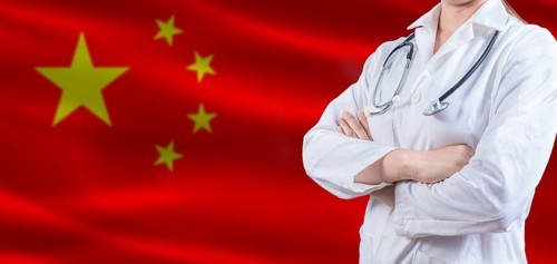 Doctor with crossed arms on China flag. China Health and Care concept. Female doctor on China flag