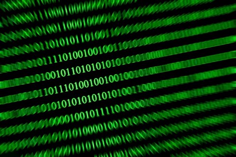 Slanted green binary code on a black background, conveys speed