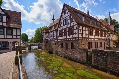 River Mümling, historic half-timbered houses, metal railings, backlight, blue sky with cumulus