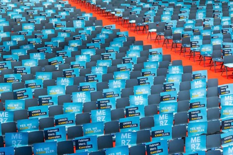 Assembly hall, deserted with many empty chairs and posters with the inscription UNSER KANNZLER.