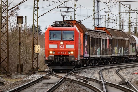 Goods train travelling on the winding Schuster Railway, overhead lines and infrastructure.