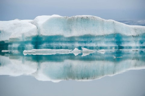 Ice formations are reflected in the still, misty water, Jökulsárlón glacier lagoon or Jökulsarlon,