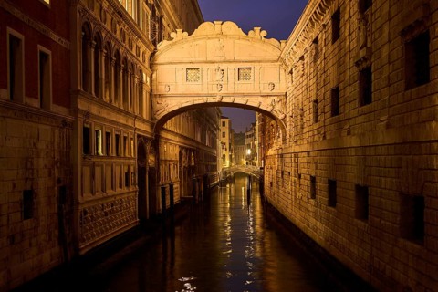View from 'Ponte della paglia' on the bridge 'Bridge of Sighs' over a waterway at the blue hour in