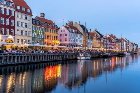 Colourful houses, restaurants and historic ships on the Nyhavn canal and harbour at dusk,