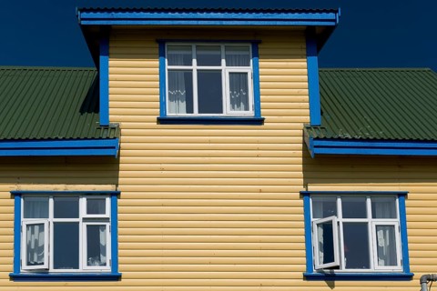 Blue-yellow-green painted wooden house, blue sky, Mykines, Útoyggjar, Faroe Islands, Denmark,