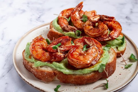 Sandwiches with avocado and caramelized shrimp, micro-greens, breakfast, on a plate, top view,