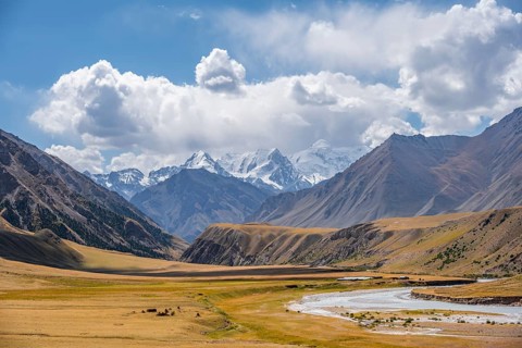 Mountain river in a valley, picturesque mountain landscape with white mountain peaks, Tian Shan