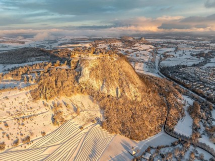 Aerial view of the snow-covered Hegau volcano Hohentwiel with Germany's largest castle ruins on a
