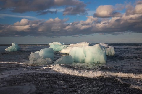 Little icebergs and crushed ice on the black beach at Joekulsarlon glacial lake