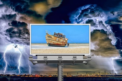 Symbolic image, storm over the city, billboard with ship on dry land, threat to paradise, water