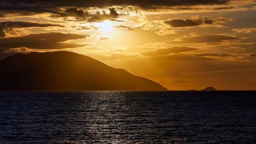 Dramatic sunset over the sea, island visible as a silhouette, Kassos island, neighbouring island