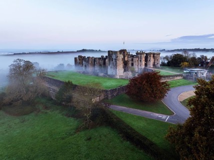 Raglan Castle in the fog at dawn from a drone, Monmouthshire, Wales, England, United Kingdom,