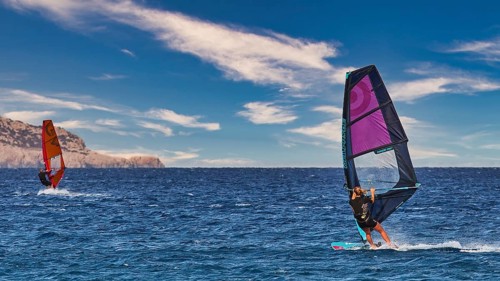 Sky exchanged, windsurfers gliding on calm sea with bright sky in the background, windsurfers,
