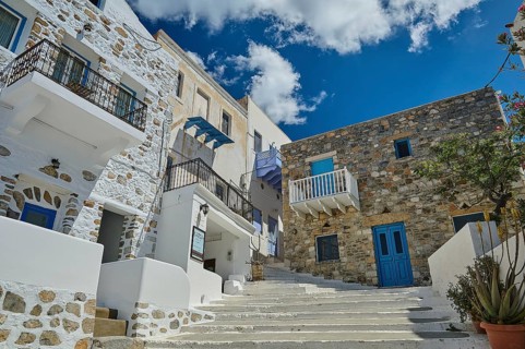 Stone and plaster houses on a picturesque staircase with a bright blue sky in the background,