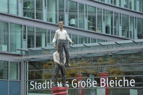 Townhouse with sculpture Two Men by Stephan Balkenhol 2001, male figure, standing on one leg,