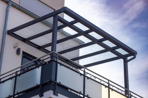 Beautiful balcony roofing made of glass and aluminium on a residential building