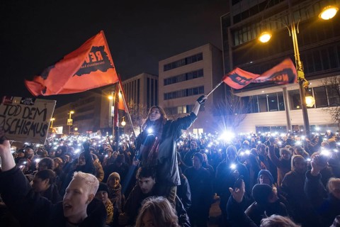 Sea of lights with flags Revolution at the demonstration under the motto Brandmauer statt