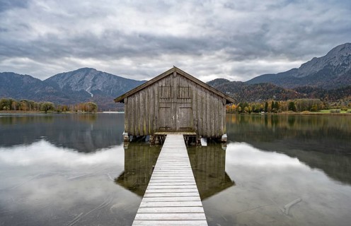 Boathouse in the lake, Lake Kochel in autumn with reflection, Upper Bavaria, Bavaria, Germany,