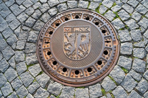 Round manhole cover with coat of arms on cobblestones, manhole cover, Melnik, Melnick, Central