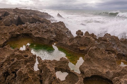 The rocks are scattered throughout the area, with some of them being large and jagged. The water
