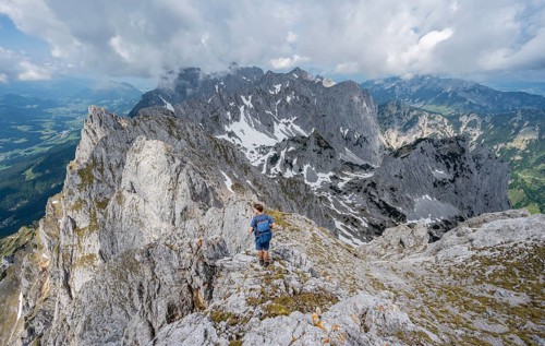 Mountaineer at the summit of the Ackerlspitze, view of rugged, rocky mountain landscape, view from