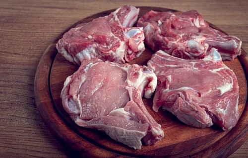 Raw calf meat, meat on the bone, meat for barbecue, cutting board, top view