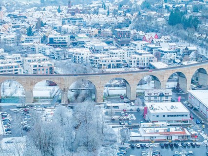 Townscape with snow-covered viaduct and houses in a winter landscape, Nagold, Black Forest,