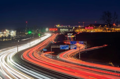 A8 motorway at Stuttgart Airport in the evening. Heavy traffic, lanes of light. Modern architecture