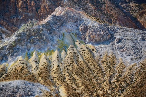 Complex geological formations in a volcanic landscape, characterised by rough stone and yellow