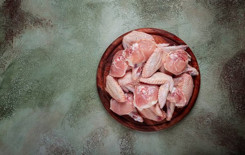 Raw chicken wings, on a wooden board, top view, no people