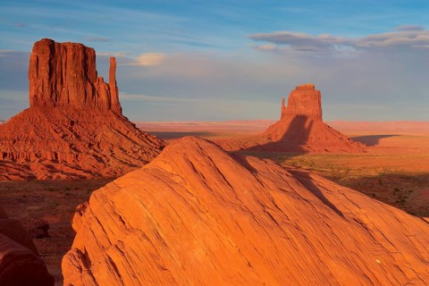 Monument Valley with majestic red sandstone formations in the desert under a clear sky in sunlight,