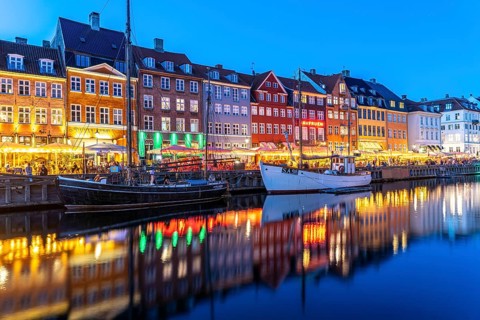 Colourful houses, restaurants and historic ships on the Nyhavn canal and harbour at dusk,