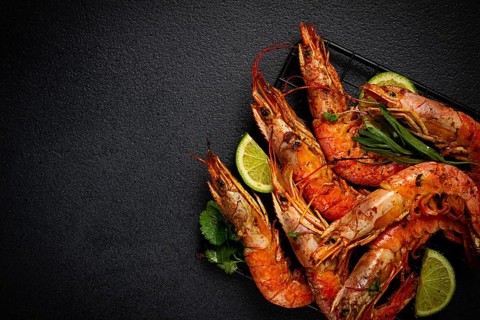 Langoustines, Australian, freshly frozen on ice, top view, lime and greens