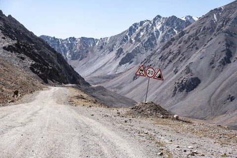 Narrow gravel track in mountain landscape at Chong Ashuu Pass, Tian Shan Mountains, Issyk-Kul,