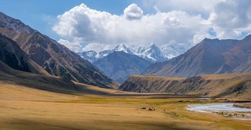 Mountain river in a valley, picturesque mountain landscape with white mountain peaks, Tian Shan
