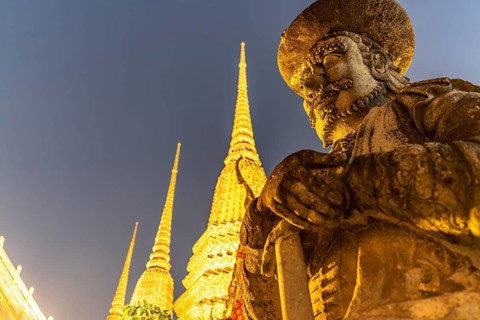 Giant Farang Guard and Chedi of the Buddhist temple Wat Pho at dusk, Bangkok, Thailand, Asia