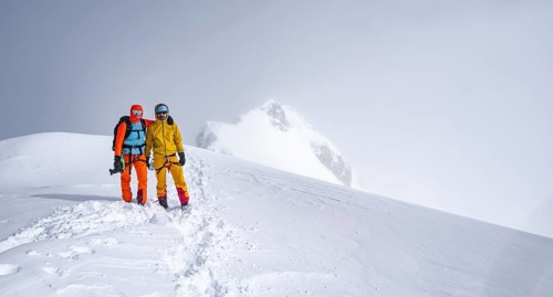 Two ski tourers on the summit of the Wildhorn, Snowy mountain landscape and fog, Bernese Alps,