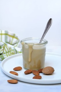 Almond cream in a jar and almonds