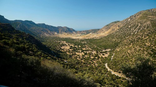 Wide valley with wooded slopes and mountains under a clear sky, volcanism, volcanic island, access