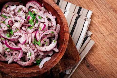 Chopped red onion, with sumac and herbs, in a bowl, pickled Spanish onion, close-up, top view