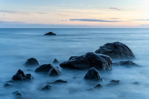 Rocks on the beach of Playa del Inglés. Sunset. Sea and waves. Long exposure. Valle Gran Rey, La