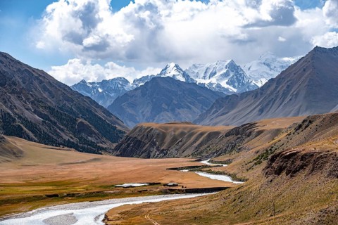 Mountain river in a valley, picturesque mountain landscape with white mountain peaks, Tian Shan