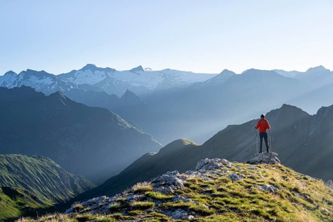 Hiker enjoying the mountain panorama in the morning, Venediger group, behind Dreiherrenkopf,