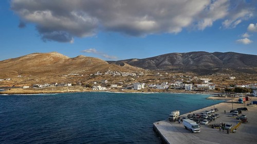 Coastal village with buildings and a harbour in the foreground, surrounded by mountains, Kassos