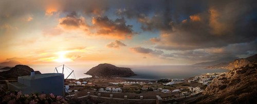Sweeping panoramic view of the coastal landscape from the town of Arkasa and windmill at sunset,