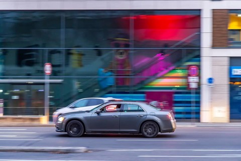 Car at night in front of urban surroundings with modern architecture, pull-along. Stuttgart,