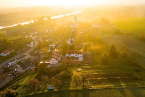 Aerial view, view of the village with St Michael's Church at sunrise, church casts a long shadow,